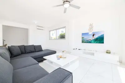 a living room with a couch and a table at Elite Blu Heights Villa in Ayia Napa