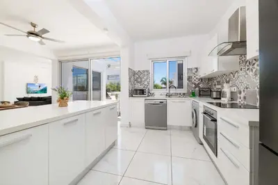 a white kitchen with white cabinets and appliances at Elite Blu Heights Villa in Ayia Napa