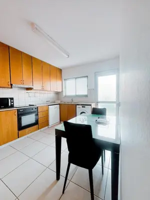 a kitchen with a table and a black chair at Ikarus in Limassol