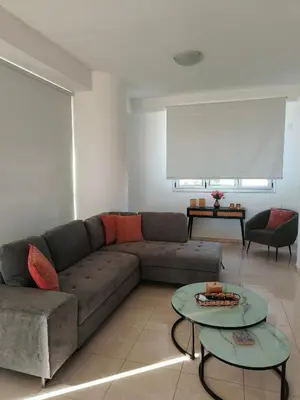 a living room with a couch and two tables at Marina City Centre Stays in Larnaka