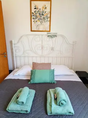 two people laying in towels on a bed at Marina City Centre Stays in Larnaka