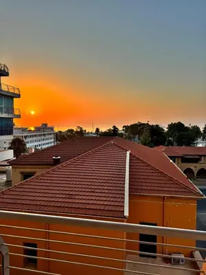 a roof of a building with the sunset in the background at Marina City Centre Stays in Larnaka