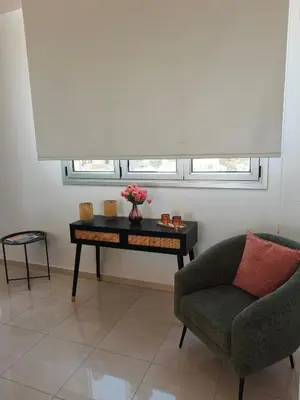a living room with a table and a chair and a couch at Marina City Centre Stays in Larnaka