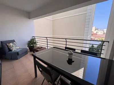 a balcony with a table and a chair in a room at Makriev Suite in Larnaka