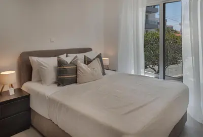 a bedroom with a bed with pillows and a window at Phaedrus Living Travertine Residences 101 in Strovolos