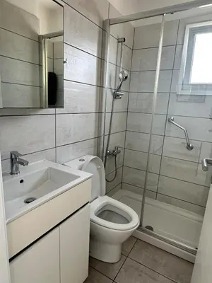 a bathroom with a toilet and a shower and a sink at Sunrise Maisonette in Voroklini
