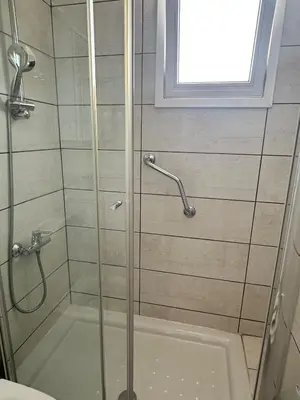 a bathroom with a shower with a glass door at Sunrise Maisonette in Voroklini