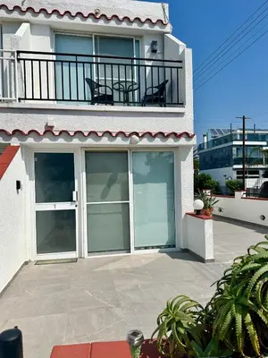 a house with a balcony with two chairs on it at Sunrise Maisonette in Voroklini