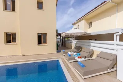 a villa with a swimming pool and a house at Villa Poseidon in Paralimni