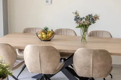 a dining room table with chairs and a vase of flowers at Milan's Mythical Villa in Paralimni