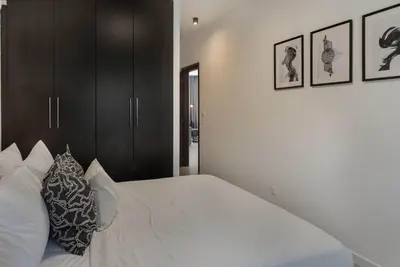 a bedroom with a large white bed with black cabinets at Phaedrus Living Travertine Residences 102 in Strovolos