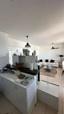a kitchen and living room with white cabinets and a couch at Kyrenia 2 bedroom apartment in Ayios Dhometios