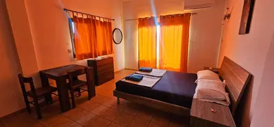a bedroom with a bed and a table and a window at Pergamonto Apartments in Ayia Napa