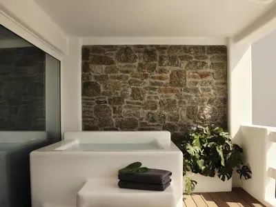 a bath tub in a room with a brick wall at Aya Resort - Adults Only in Ayia Napa