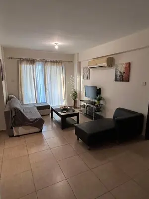 a living room with a couch and a tv at Modern 2BR Appartment near Finikoudes beach - Larnaka in Larnaka