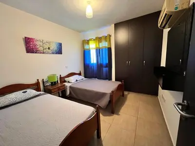 a hotel room with two beds and a television at Modern 2BR Appartment near Finikoudes beach - Larnaka in Larnaka