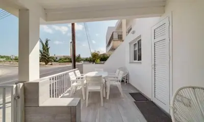 a patio with a table and chairs on a balcony at Deluxe Apt - 500m Nissi Beach! in Ayia Napa