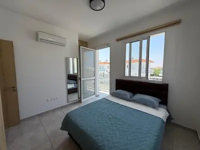 a bedroom with a bed and a large window at Sun & Sea House in Paralimni