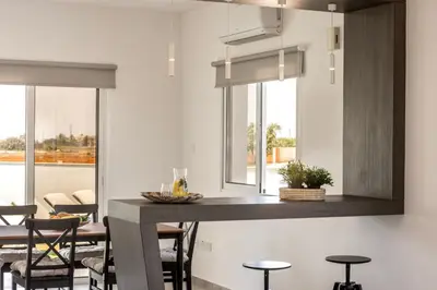 a kitchen with a island with chairs and a counter top at Ayia Napa Bay View Villa 6 in Ayia Napa