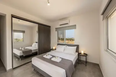 a bedroom with two beds and a large mirror at Ayia Napa Bay View Villa 6 in Ayia Napa