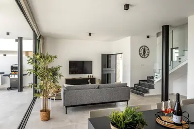 a living room with a couch and a tv at Protaras Aqua Pearl Villa 3 in Protaras