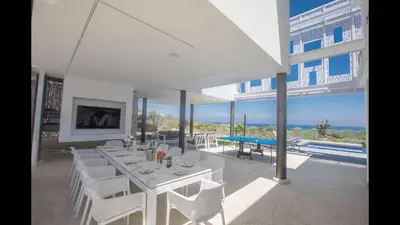 a white dining room with a table and white chairs at Villa Prcv614, Luxury 6bdr Protaras Villa with Pool and Panoramic Sea views in Protaras