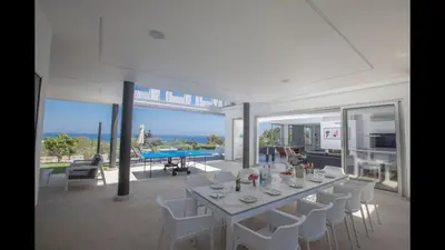 a dining room with a white table and white chairs at Villa Prcv614, Luxury 6bdr Protaras Villa with Pool and Panoramic Sea views in Protaras