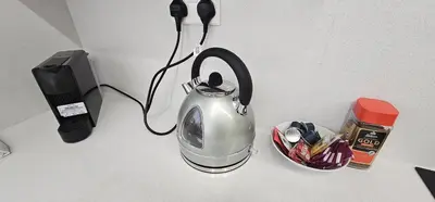 a tea kettle sitting on a counter next to a phone at Trendy Neapolis Beach Apartment in Limassol