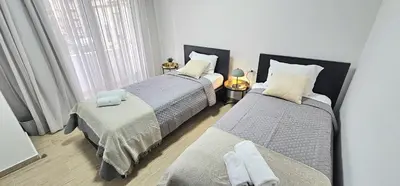 a bedroom with two beds and a window at Trendy Neapolis Beach Apartment in Limassol