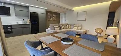 a kitchen and a living room with a table and chairs at Trendy Neapolis Beach Apartment in Limassol