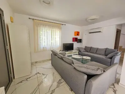 a living room with two couches and a television at Nissi beach villa Azure in Ayia Napa