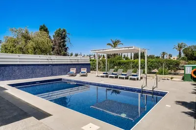 a swimming pool with chairs and a gazebo at Villa Zina by Ezoria Villas in Meneou