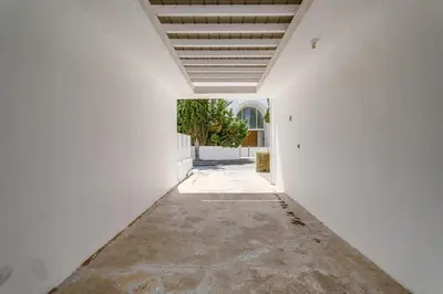 an empty hallway with a white wall and a plant at Villa Zina by Ezoria Villas in Meneou