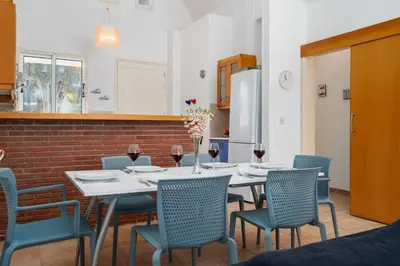 a dining room with a table and chairs with wine glasses at Villa Zina by Ezoria Villas in Meneou