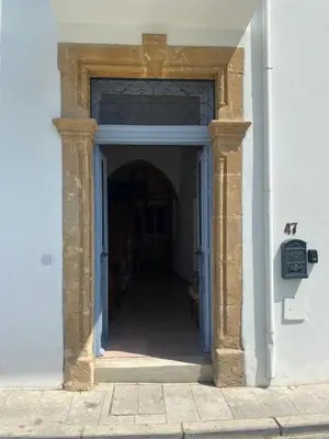 an entrance to a white building with a blue doorway at ToHaniMou - Kamara Medium Studio in Nicosia