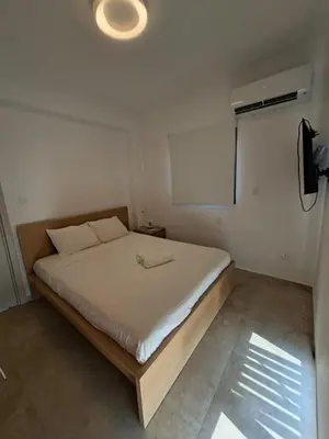a bedroom with a bed in a room with a fan at Nadine sea side villas in Larnaka