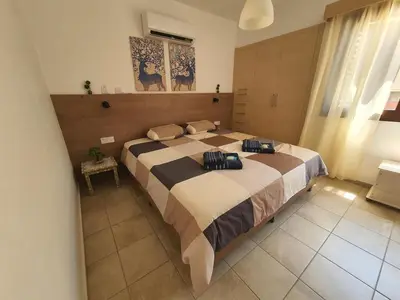 a bedroom with a large bed in a room at Lovely ground floor apartment with BBQ in Aglantzia