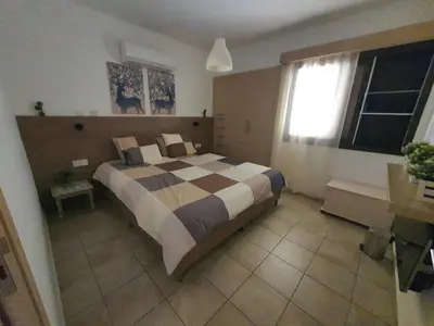a bedroom with a bed and a window in it at Lovely ground floor apartment with BBQ in Aglantzia