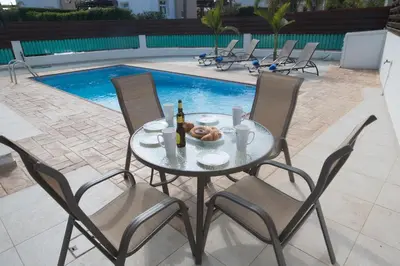 a table with a bowl of donuts and bottles of beer at Protaras Holiday Villa Me25 in Protaras