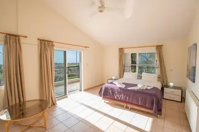a bedroom with a bed and a large window at Ayia Napa Holiday Villa At26 in Ayia Napa