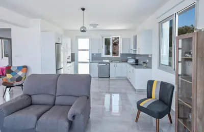 a living room with a couch and a kitchen at Villa Clea,stunning 4bdr Protaras Villa, Seaviews in Protaras