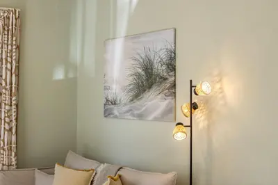a living room with a couch and a picture of a beach at Laranca Oneiro Seaside Villa in Pervolia