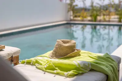 a hat sitting on a towel next to a swimming pool at Protaras Aqua Pearl Villa 9 in Protaras