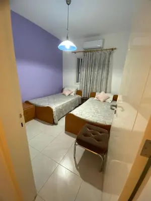 a small room with two beds and a chair at Sunny 2BR Home in Paralimni Near Beaches,Protaras! in Paralimni