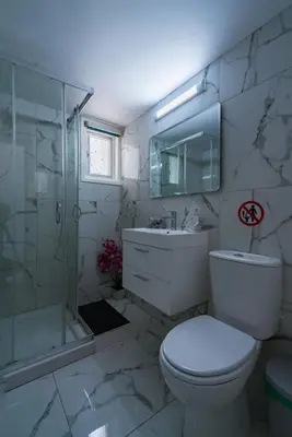 a bathroom with a toilet and a shower and a sink at Central & Cozy Larnaca Suite in Larnaka