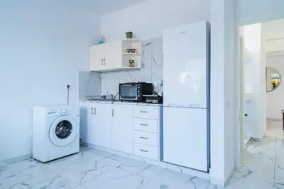 a kitchen with a washing machine and a washer at Central & Cozy Larnaca Suite in Larnaka