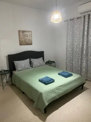 a bedroom with a bed with two towels on it at Sweet Home Apartment 3-Bedrooms in Larnaka