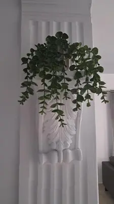 a white vase with a plant in front of a curtain at Sweet Home Apartment 3-Bedrooms in Larnaka