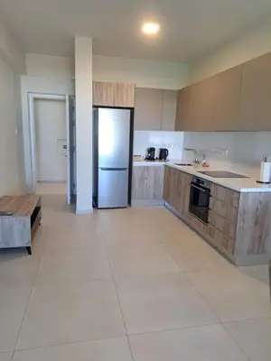 a large kitchen with a refrigerator and a table at Modern Cosy Holiday Apartment in Paralimni