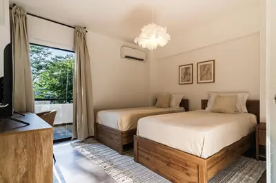 two beds in a room with a tv and a window at City Centre Modern Boho Stay in Nicosia